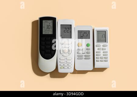 Air conditioner remote controls on beige background Stock Photo