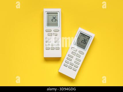 Air conditioner remote controls on yellow background Stock Photo