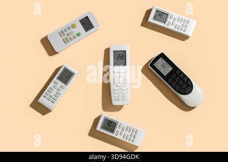Air conditioner remote controls on beige background Stock Photo
