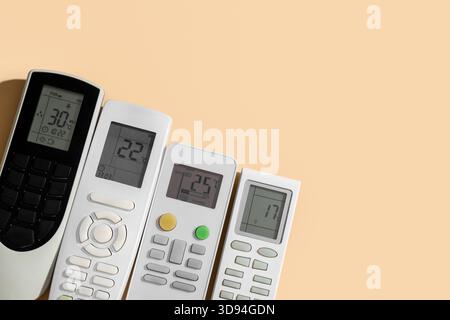 Air conditioner remote controls on beige background Stock Photo