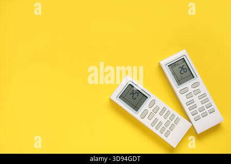 Air conditioner remote controls on yellow background Stock Photo