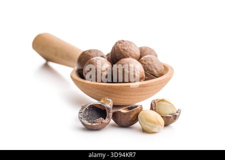 Tasty macadamia nuts on wooden spoon isolated on a white background. Stock Photo