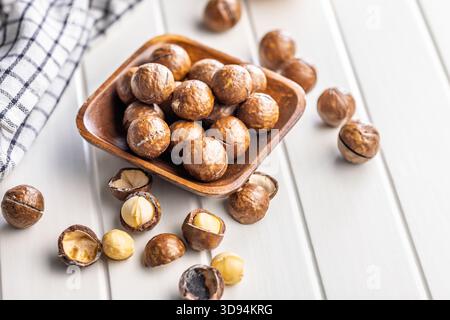 Tasty macadamia nuts in bowl on a white table. Stock Photo