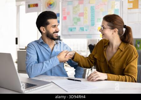 Happy new business partners shaking hand at office workplace table Stock Photo