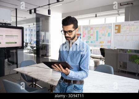 Serious young Middle Eastern startup leader man using tablet Stock Photo