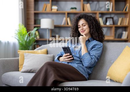 Young woman with curly hair engages in remote work at her comfortable ...