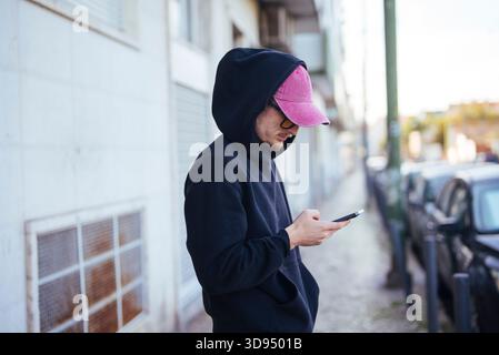 Person confirms package delivery using smartphone on busy street Stock Photo