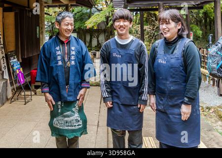 Three staff members of the Amazake Chaya (�ʾƲ���) in front of the entrance to the traditional teahouse on the historic Hakone Trail, Hakone, Kanagawa Prefecture, Japan. The establishment has been family-owned for several centuries and served as a resting place for travellers on the old T��kaid�� Stock Photo