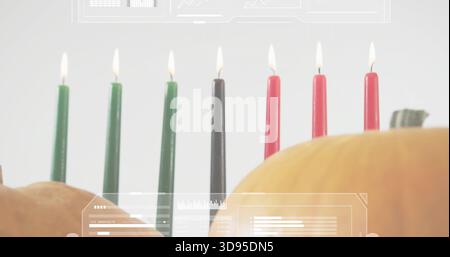 Showing seven lit taper candles green-black-red on table with two pumpkins and faint HUD overlays Stock Photo