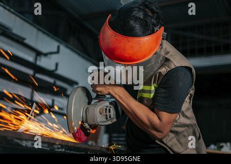 Man using a grinder in a workshop. Metalworking professional using an angle grinder in the workshop Stock Photo