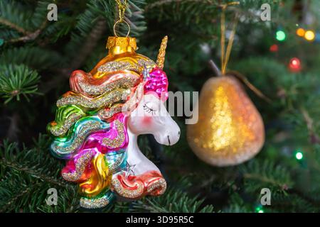 Unicorn glass hanging ornament hanging in a Christmas tree. Stock Photo