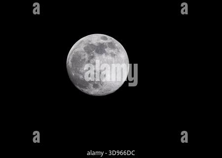 Cold supermoon, last full moon of 2025, isolated against black night sky as seen from Virginia USA Stock Photo