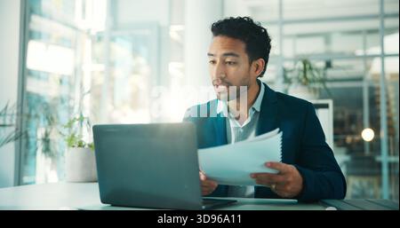 Document, accountant and business man on laptop for sales revenue, reading report and issue. Computer, paperwork and auditor check information, profit Stock Photo
