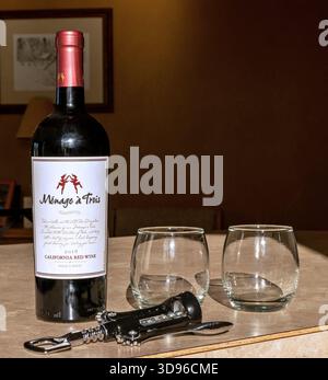 BEMIDJI, MN - 15 MAY 2020: Unopened bottle of red wine with two stemless glasses and a corkscrew on a counter ready to open. Stock Photo