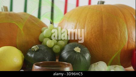 Displaying still-life scene showing two pumpkins and squash on light table with grapes lemon garlic Stock Photo
