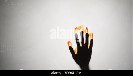 Reaching dark hand showing glowing flame fingertips at studio backdrop, cyan code lines, copy space Stock Photo
