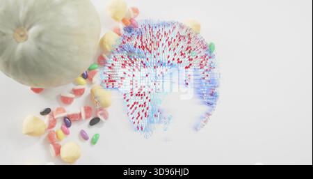 Displaying holographic globe with red pins hovering on white table, with melon and candies Stock Photo