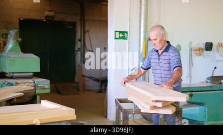 Senior carpenter working with wood in workshop Stock Photo