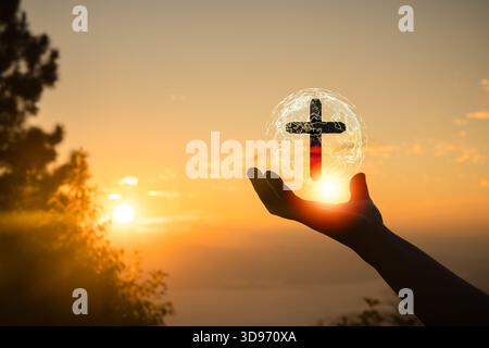 Human hand holding Christian cross with a sunset sky background Stock ...