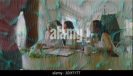 Sitting four women reviewing documents at office meeting table wearing business casual teal overlay Stock Photo