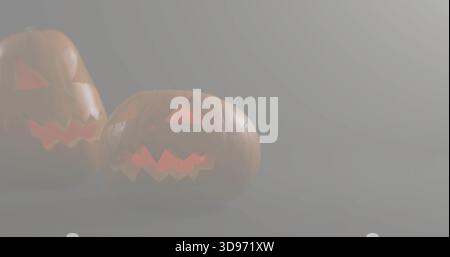 Glowing carved pumpkins emitting warm orange light in dim foggy studio on matte surface, copy space Stock Photo