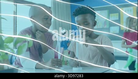 Measuring liquid, two students wearing layered shirts using dropper with vial in classroom Stock Photo