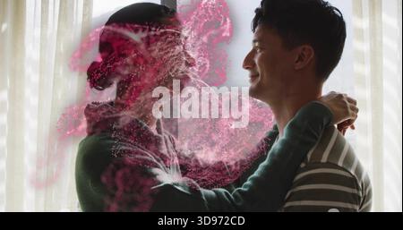 Embracing couple wearing green sweater and striped shirt standing at window, pink powder swirling Stock Photo