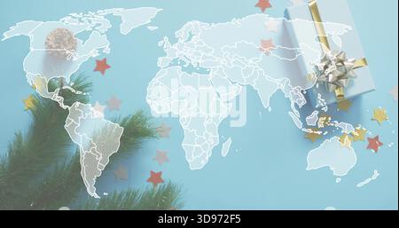 Displaying white world map outline across blue sheet showing pine branch, gift box, gold confetti Stock Photo