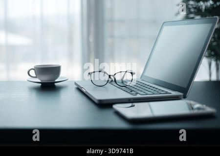 Office workplace with laptop and smart phone on wood table. Workspace, desktop computer, office supplies, houseplant and books at office. desk work co Stock Photo