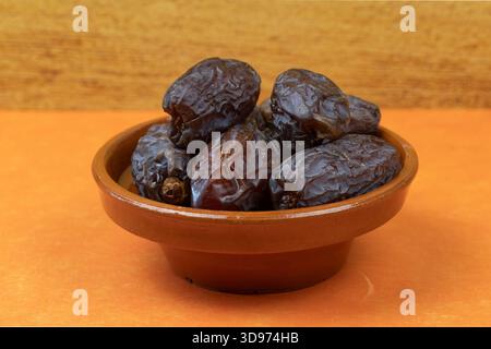 Dried dates in a traditional bowl Stock Photo
