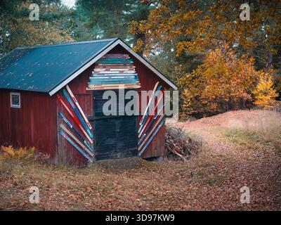 Rustic shed decorated with old skis in autumn forest setting at a ski lodge Stock Photo