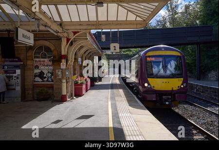 The 10:54 East Midlands Railway service from Nottingham arrives in platform 1 at Matlock station comprising a 3-car Class 170 diesel-multiple unit. Stock Photo