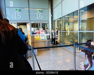 Krakow, Poland - November 07, 2025: Busy scene at Krakow airport in Poland with staff, passengers, and security barriers. Stock Photo
