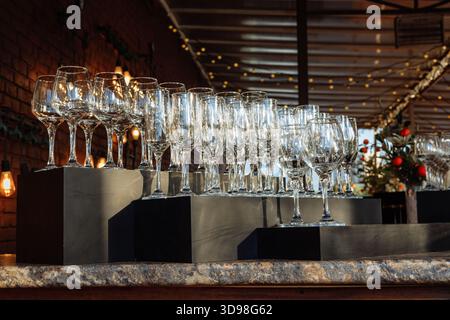Rows of empty wine and champagne glasses on bar counter - ready for a party. Stock Photo