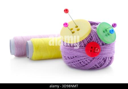 Ball of bright knitting yarn with buttons, spools of thread and pins isolated on white Stock Photo