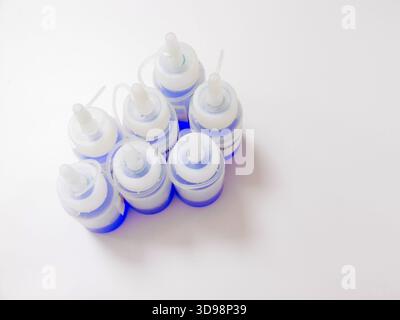 Stacked Bottles Nozzle Caps Closeup, BlueCapped Plastic Bottles Arranged In Grid, Disposable Dropper Tips Stock Photo