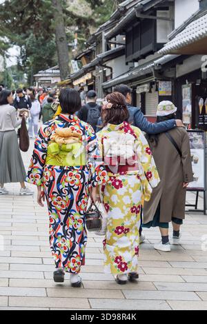 Nara, Japan - Mach 28, 2025: Two woman in traditional and colorful Japanese kimono with flower print walking between tourist in Todai-ji temple comple Stock Photo