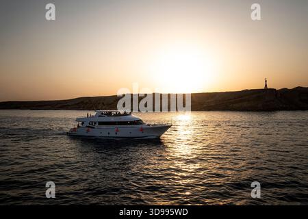 Yacht in the rays of the setting sun against the island of Tirana. Red sea. Egypt. Stock Photo