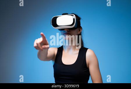 Woman using virtual reality headset and interacting with digital interface in immersive VR environment Stock Photo