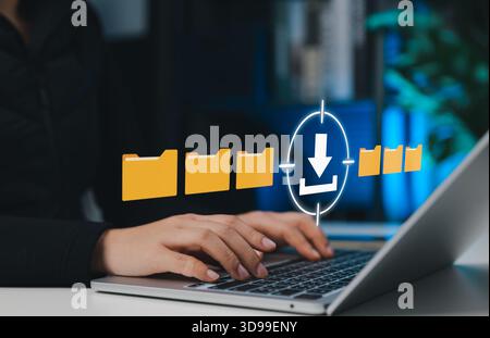 File download and data access concept, showing a woman using laptop with digital folder icons and download symbol, representing cloud storage, data Stock Photo