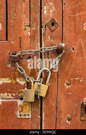 old brown wooden door, with chain and locks Stock Photo