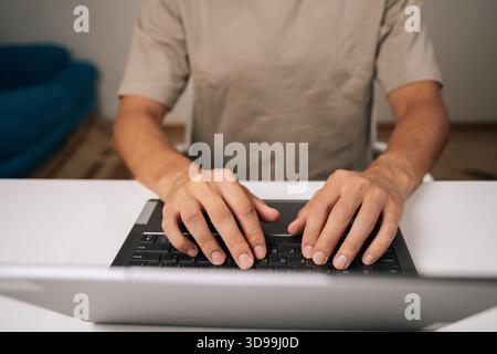Close-up top view of programmer male hands typing code on laptop keyboard, showcasing process of software development and coding expertise. Stock Photo