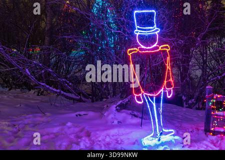 Festive holiday light display featuring a glowing toy soldier figure and trees decorated Christmas lights, Confederation Park, Calgary Alberta Canada Stock Photo
