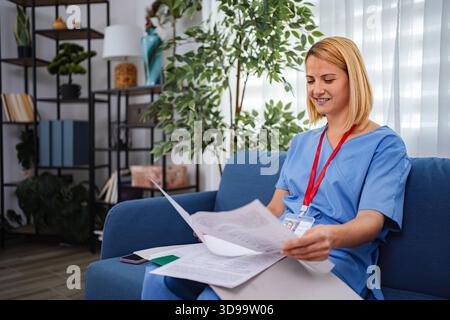 Female Doctor Reviewing Medical Records at Home Office Stock Photo