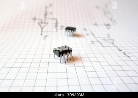 Semiconductor ntegrated circuit standing on logic circuit drawings. Industrial electronic projects concept. Stock Photo