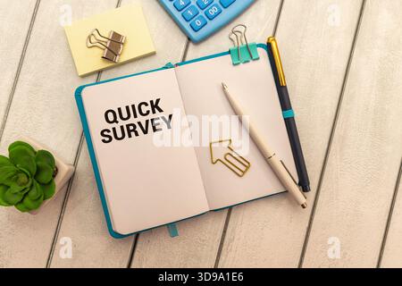 Quick Survey text written on notepad with alarm clock on blue background Stock Photo