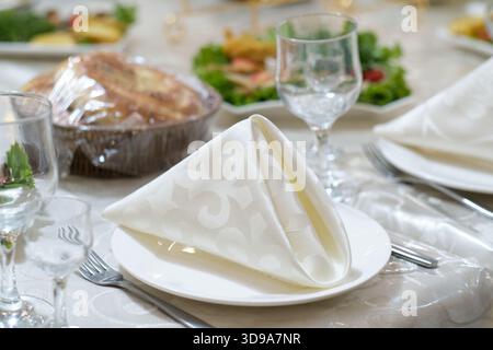 Table set for an event party or wedding reception. Plates and cutlery on table Stock Photo