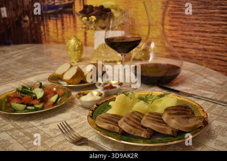 Grilled beef tongue with red wine in glass decanter. Stock Photo