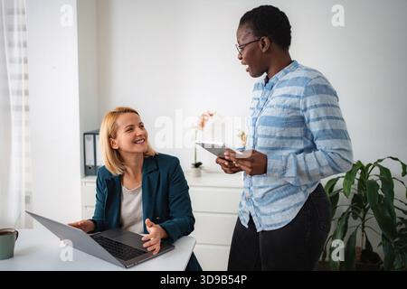 Businesswomen collaborating on project in modern office Stock Photo