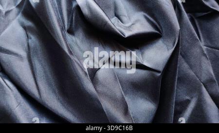 Luxurious Black Technical Woven Fabric Texture Background with Deep Shadows and Sharp Creases for Modern Apparel Design Stock Photo
